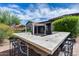 This outdoor kitchen boasts a large bar with tile details, offering a perfect space for entertaining guests in the backyard at 29214 N 19Th Ln, Phoenix, AZ 85085