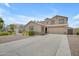 Inviting beige two-story home with a spacious driveway and desert landscaping at 3349 E Flamingo Ct, Gilbert, AZ 85297