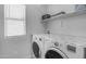 Bright laundry room featuring side-by-side washer and dryer with marble countertop above at 3349 E Flamingo Ct, Gilbert, AZ 85297