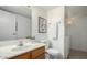 Bathroom with wood cabinet vanity, toilet, and laundry closet at 3511 E Baseline Rd # 1235, Phoenix, AZ 85042
