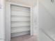 White shelving and a neutral color scheme in this walk-in closet providing ample storage with a carpeted floor at 3511 E Baseline Rd # 1235, Phoenix, AZ 85042