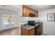 Kitchen featuring wood cabinets, granite countertops, black appliances, and view to the living room with double doors at 3511 E Baseline Rd # 1235, Phoenix, AZ 85042