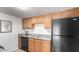 Shot of the kitchen featuring wood cabinets, black appliances, granite countertops and a stainless steel sink at 3511 E Baseline Rd # 1235, Phoenix, AZ 85042