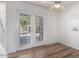 Bright living area featuring wood floors, ceiling fan, and double doors to the outside at 3511 E Baseline Rd # 1235, Phoenix, AZ 85042