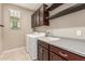 Well-lit laundry room featuring modern washer and dryer, sink with gray countertops, and dark wood cabinets at 3637 E Ebano St, Gilbert, AZ 85295