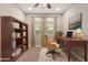 Inviting home office with a wooden desk, bookshelf, and neutral-toned walls at 3637 E Ebano St, Gilbert, AZ 85295