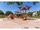 Community playground featuring covered play structures and climbing structures on a sand base at 3637 E Ebano St, Gilbert, AZ 85295