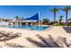 Large community swimming pool and lounge area with palm trees and blue awning at 3637 E Ebano St, Gilbert, AZ 85295