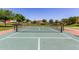 Outdoor tennis court with net and surrounding trees in a well-maintained community at 3637 E Ebano St, Gilbert, AZ 85295