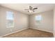 Bedroom with neutral tones, two bright windows, and soft carpet flooring at 3914 S 58Th Ln, Phoenix, AZ 85043