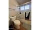 Well-lit bathroom featuring a shower-tub combo with a glass door and tiled walls, offering a clean and modern space at 4016 E Western Star Blvd, Phoenix, AZ 85044