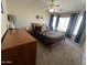 Comfortable bedroom with a queen-size bed, ceiling fan, dresser, and natural light from large windows at 4016 E Western Star Blvd, Phoenix, AZ 85044