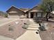 A charming house with a beige exterior, a two-car garage, mature landscaping, and a stone walkway at 4016 E Western Star Blvd, Phoenix, AZ 85044