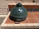 Close up of the outdoor kitchen's Big Green Egg smoker on a tile counter, ideal for gourmet BBQ at 4016 E Western Star Blvd, Phoenix, AZ 85044