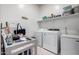 A well-equipped laundry room with a washer, dryer, shelving, and a utility sink at 4044 E Dawson E Dr, Chandler, AZ 85249