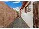 Side yard with decorative rock, brick wall, and access to the back and the home's exterior with painted brick and red trim at 4144 N 29Th Ave, Phoenix, AZ 85017