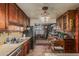 This is a kitchen area with wood cabinets, appliances, tile flooring and view into the carpeted living area at 4144 N 29Th Ave, Phoenix, AZ 85017
