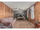 Cozy living room with wood paneling, a unique stone accent wall, and a comfortable seating arrangement at 4144 N 29Th Ave, Phoenix, AZ 85017