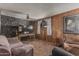 Cozy living room with wood paneling, a unique stone accent wall, and a comfortable seating arrangement at 4144 N 29Th Ave, Phoenix, AZ 85017
