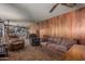 Large living room featuring wood paneling, vintage carpet, and comfortable seating and a vintage ceiling fan at 4144 N 29Th Ave, Phoenix, AZ 85017