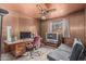 Home office setup with paneled walls, ceiling fan, desk, and futon couch, creating a functional workspace at 4144 N 29Th Ave, Phoenix, AZ 85017