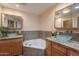 Bright bathroom featuring double sinks, wooden cabinets and a tiled backsplash, complete with a soaking tub at 4349 W Cielo Grande --, Glendale, AZ 85310