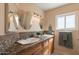 Well-lit bathroom boasts dual sinks, a window, decorative tile counters, and ample lighting at 4349 W Cielo Grande --, Glendale, AZ 85310