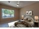 Stylishly furnished bedroom features a ceiling fan and a large window overlooking a scenic tree at 4349 W Cielo Grande --, Glendale, AZ 85310