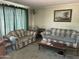 Cozy living room featuring comfortable plaid sofas and a vintage aesthetic at 4410 N 50Th Dr, Phoenix, AZ 85031