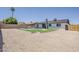 An expansive backyard with a sparkling pool, lush green grass, and a covered patio at 4509 E La Puente Ave, Phoenix, AZ 85044
