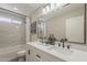 A beautifully renovated bathroom boasts double sinks, marble backsplash and black hardware at 4509 E La Puente Ave, Phoenix, AZ 85044