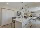 Open concept kitchen with quartz countertops, white cabinets, modern lighting, and adjacent living area at 4509 E La Puente Ave, Phoenix, AZ 85044