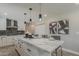 Modern kitchen with quartz countertops, gray tile backsplash, black pendant lights, and stainless steel appliances at 4509 E La Puente Ave, Phoenix, AZ 85044