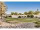 Expansive backyard featuring lush lawn, desert landscaping, and a community pool in the distance at 5445 E Mckellips Rd # 23, Mesa, AZ 85215