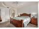 Comfortable bedroom with a large bed, ceiling fan, wood furniture, and a doorway to the bathroom at 5445 E Mckellips Rd # 23, Mesa, AZ 85215