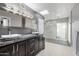 Bright bathroom features dual sinks, granite counters, modern fixtures, and frameless glass shower at 6112 E Jenan Dr, Scottsdale, AZ 85254