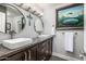 Bathroom features dual sinks, granite counters, modern fixtures, and unique decorative art at 6112 E Jenan Dr, Scottsdale, AZ 85254