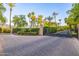 Community gate with pavers, mature landscaping, and desert plants at 6112 E Jenan Dr, Scottsdale, AZ 85254