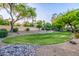 Neighborhood park with mature trees, grass, gravel rock area, and desert plants at 6112 E Jenan Dr, Scottsdale, AZ 85254