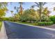 View of a pristine community road with lush landscaping and mature trees at 6112 E Jenan Dr, Scottsdale, AZ 85254