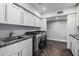 Laundry room features cabinets, granite counter, modern washer and dryer, and hardwood flooring at 6112 E Jenan Dr, Scottsdale, AZ 85254