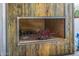 Custom outdoor fireplace with rustic wood surround, brick interior, and decorative neon lighting at 6112 E Jenan Dr, Scottsdale, AZ 85254