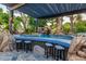 Outdoor poolside bar with seating, waterfall feature, and tropical landscaping at 6112 E Jenan Dr, Scottsdale, AZ 85254