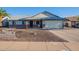 Charming single-story home featuring desert landscaping, a two-car garage, and a welcoming front porch at 6311 E Ivy St, Mesa, AZ 85205