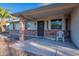 Cozy front porch with decorative brick accents, a comfortable seating area, and a well-maintained entrance at 6311 E Ivy St, Mesa, AZ 85205
