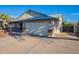 Home exterior highlighting the two-car garage and side yard, with a well-kept driveway and desert landscaping at 6311 E Ivy St, Mesa, AZ 85205