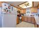 Well-lit kitchen features natural wood cabinets, ceiling fan, and white appliances at 6311 E Ivy St, Mesa, AZ 85205
