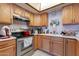 A warm kitchen with light wood cabinets, stainless steel oven, and white countertops at 6311 E Ivy St, Mesa, AZ 85205