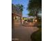 Outdoor living space featuring a brick patio, fire pit, string lights, and mature trees at dusk at 6350 S Four Peaks Pl, Chandler, AZ 85249