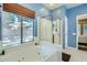 Well-lit bathroom featuring a glass-enclosed shower and garden tub overlooking the yard at 6350 S Four Peaks Pl, Chandler, AZ 85249